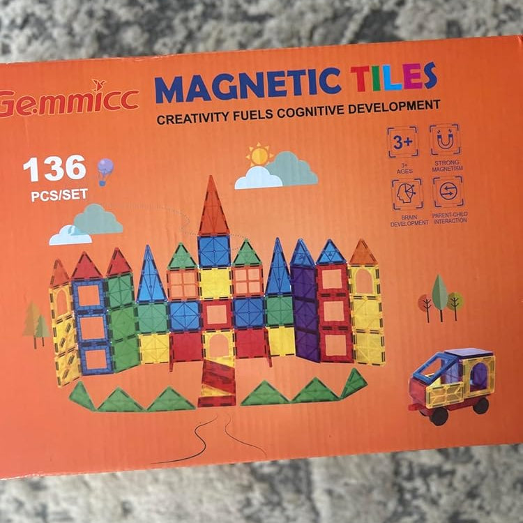 Box of Gemmicc magnetic tiles with colorful tiles on an orange background